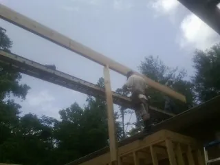 Carpenter setting a ridge beam over a new addition frame — Ice Dam Removal by Roofing Brothers in Bernardsville