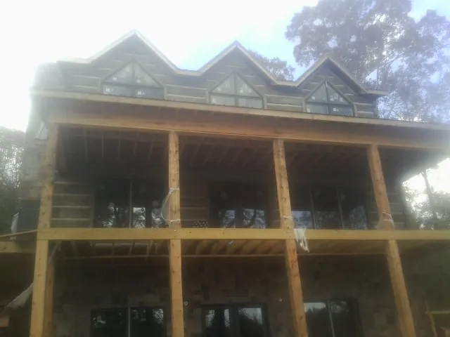 Dormers and porch framing on a large log home under construction — Roof Coating work by our crew in Bernardsville