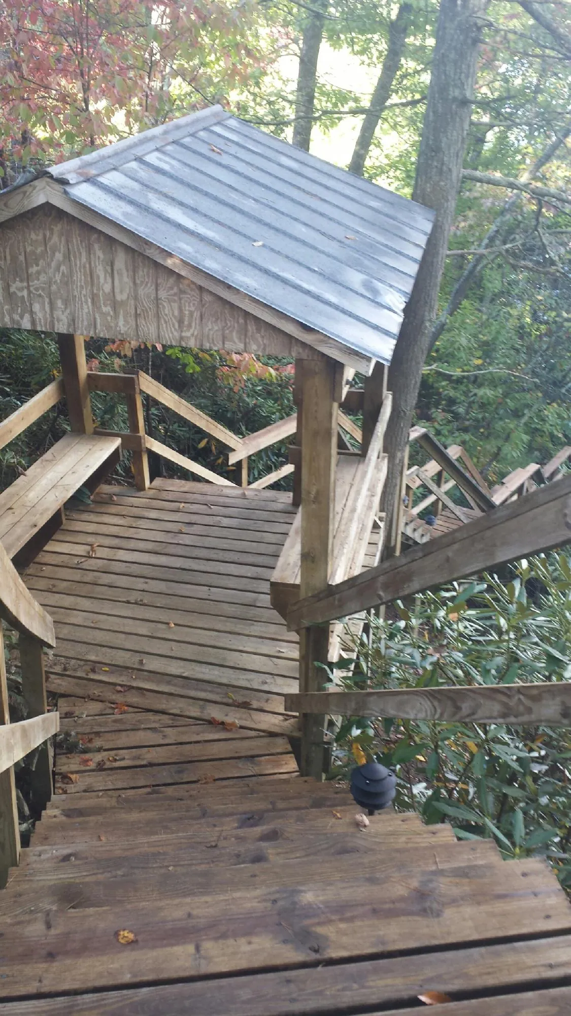 Metal roofed shelter over wooden steps on a wooded walkway — Skylight Repair & Installation work by our crew in Bernardsville