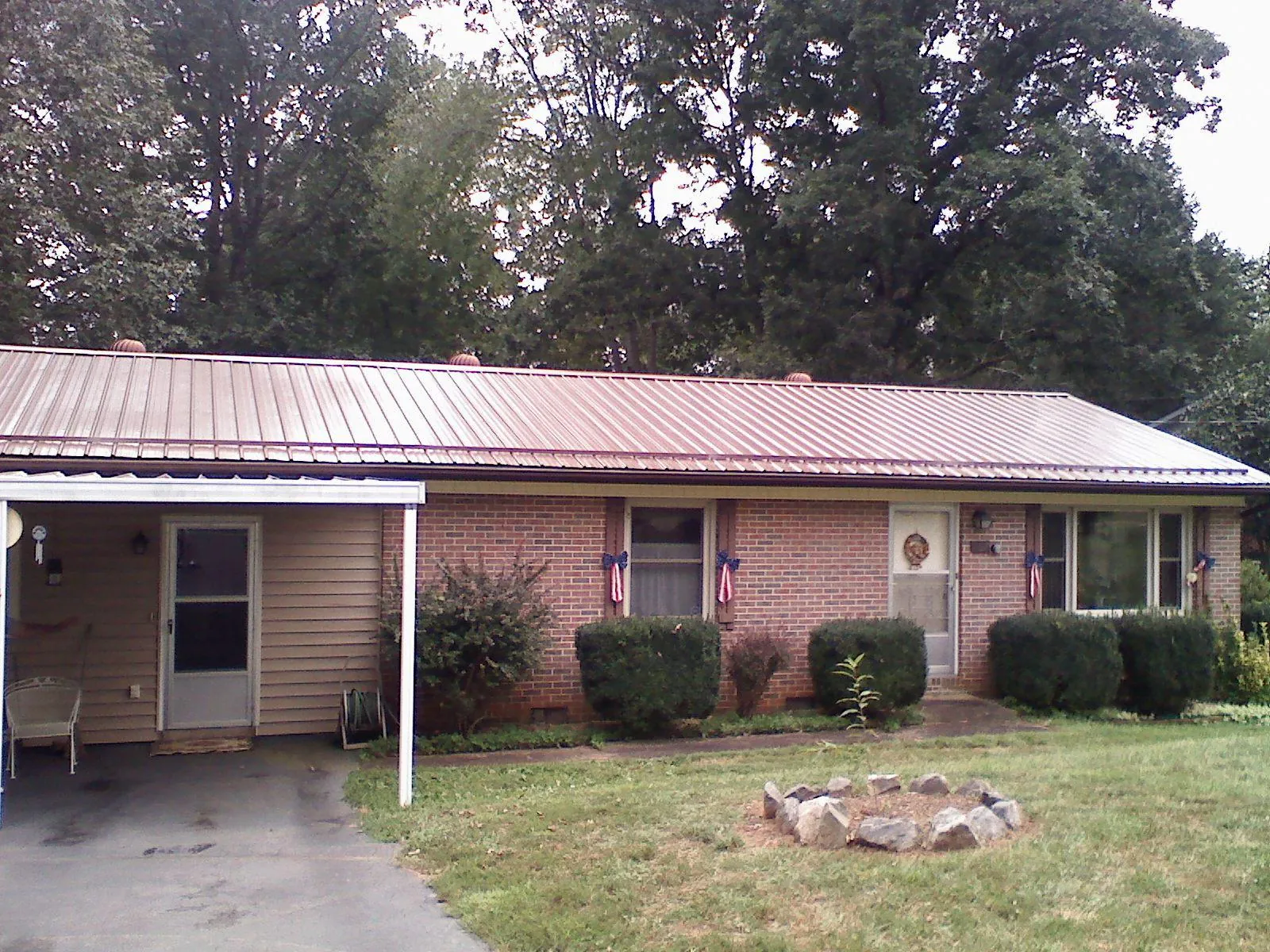 Bronze metal roof and carport on a brick ranch home — Roof Repair work by our crew in Bernardsville